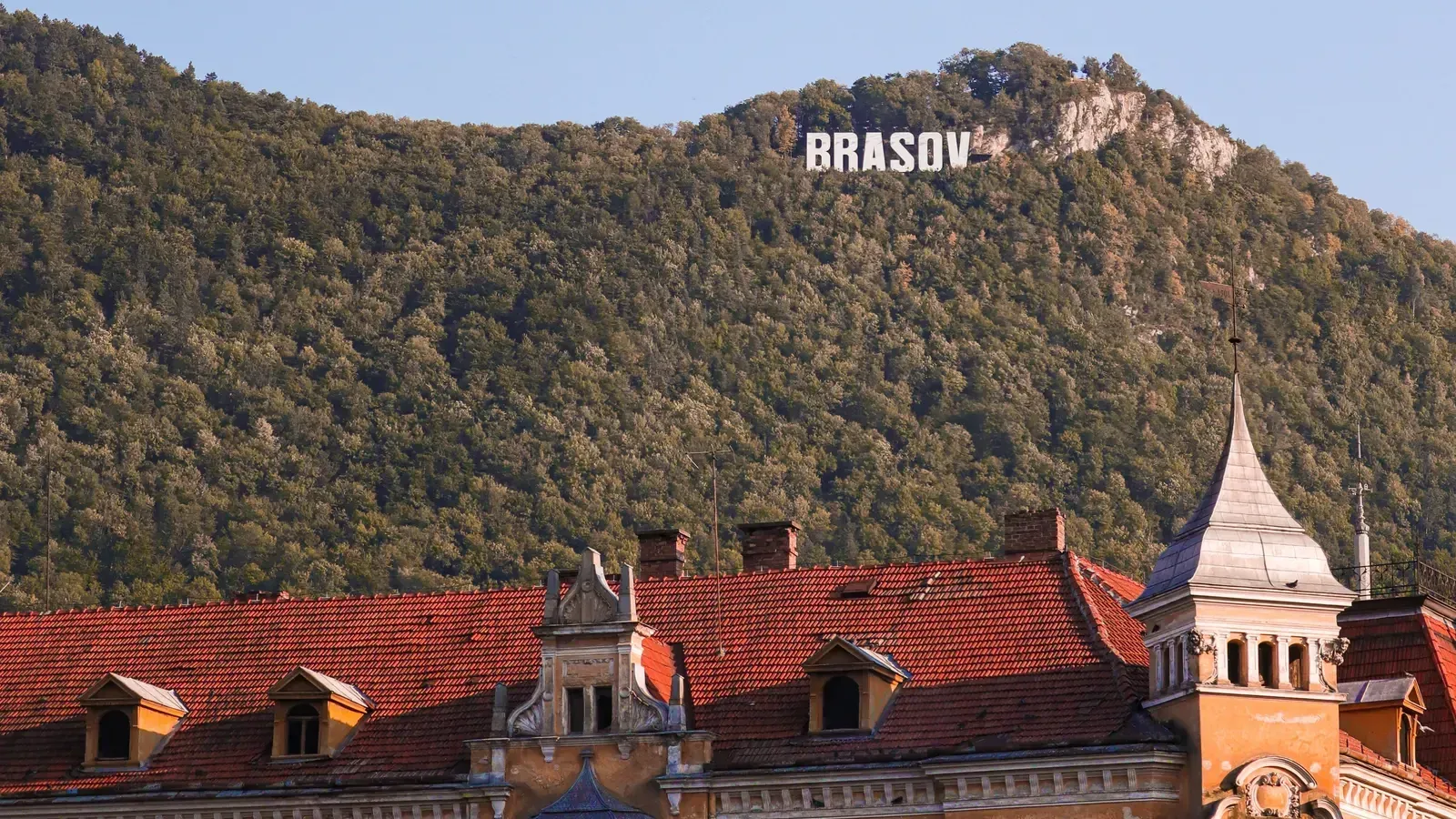 The Brașov sign on Mount Tâmpa above the red rooftops of the old town