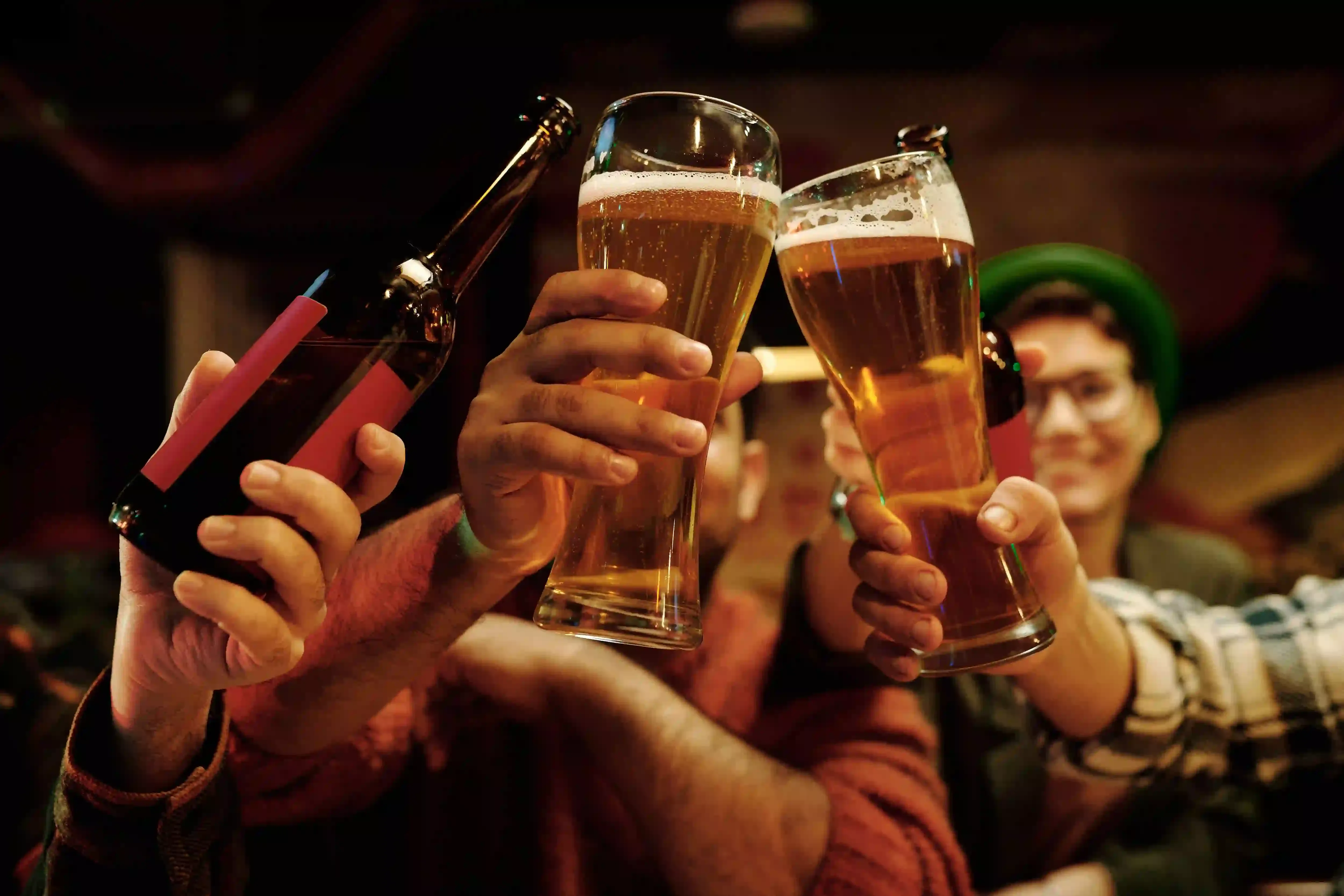 Friends raising glasses of beer in a toast at a pub
