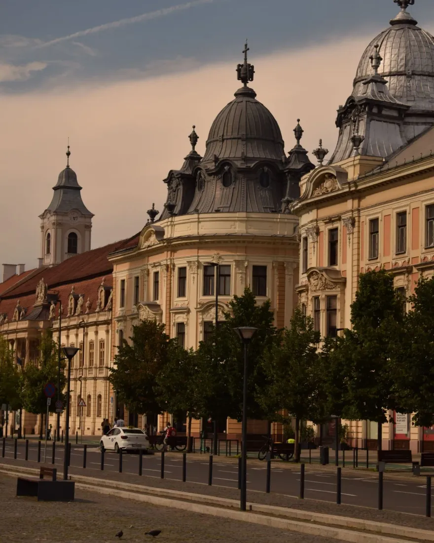 Historic buildings with ornate domes on a street in the centre of Cluj-Napoca