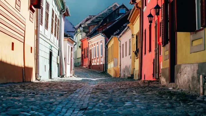 Una strada acciottolata e colorata con case antiche in una città della Transilvania