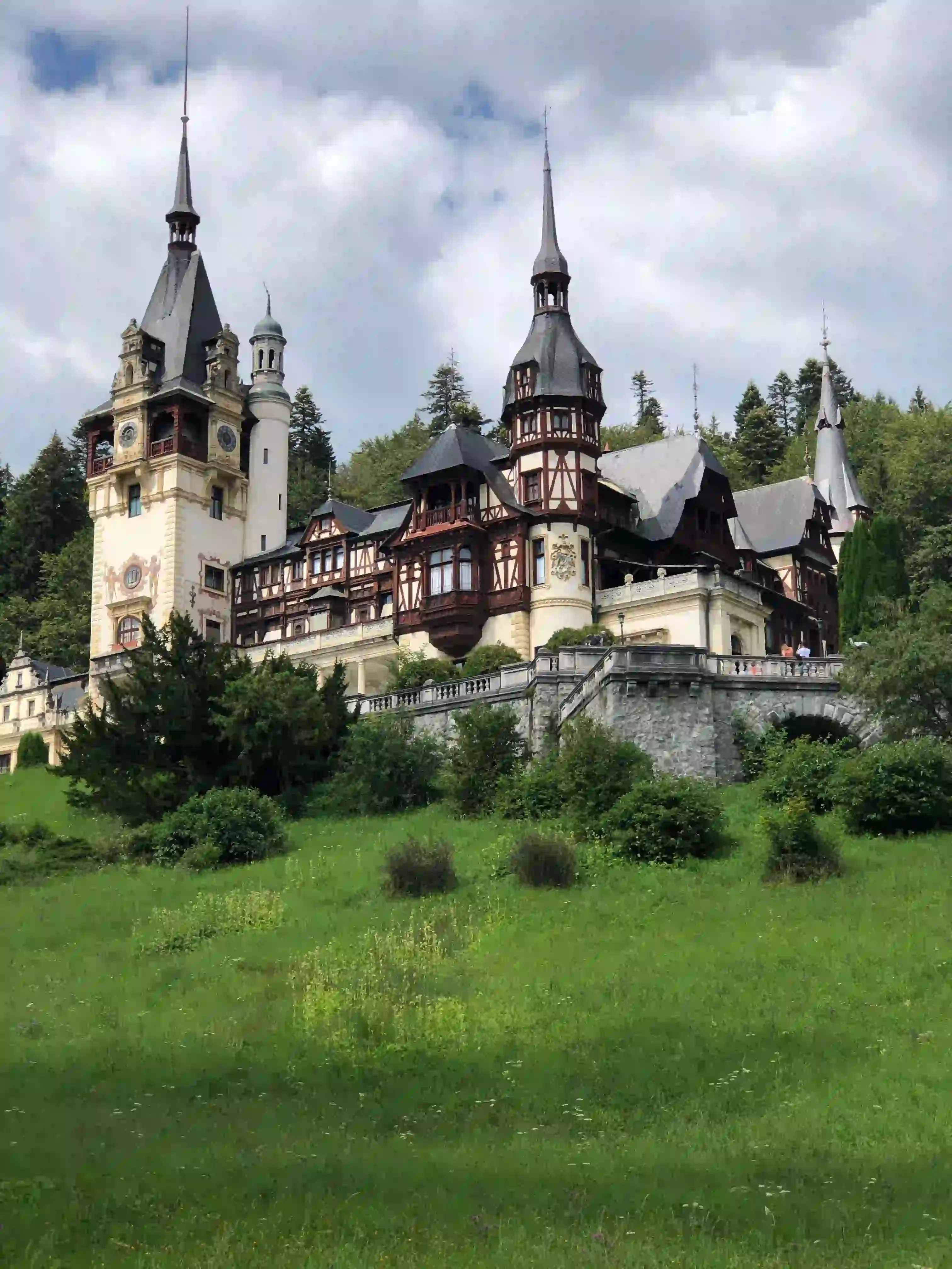 Peleș Castle with its spires above a green lawn in Sinaia