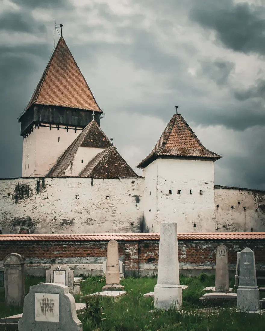 A medieval fortified church with towers and defensive walls in a Transylvanian village