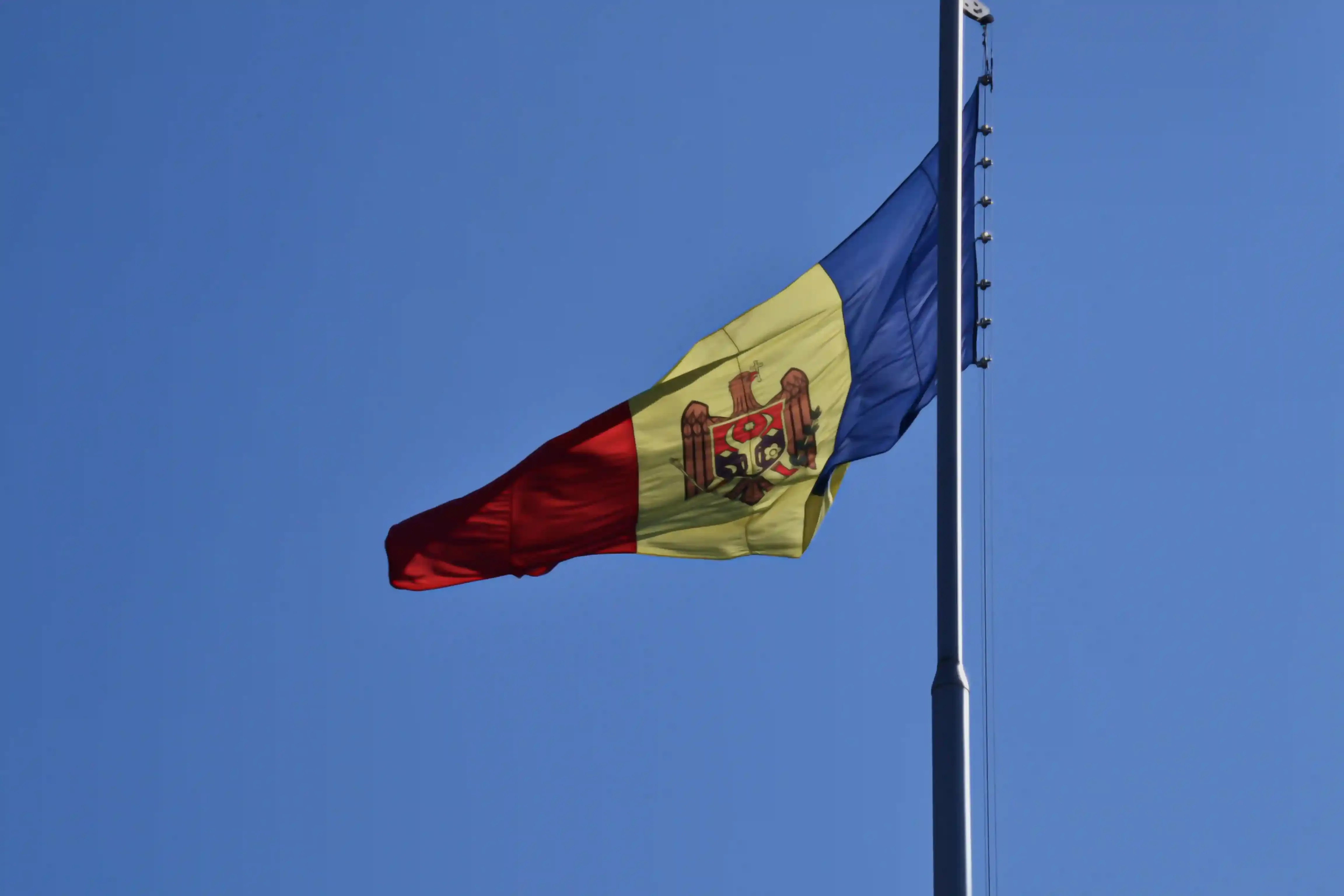 Flag of the Republic of Moldova waving against a blue sky