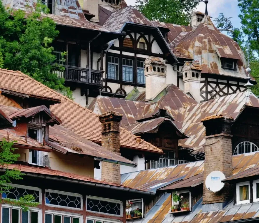 Historic villas with steep wooden roofs among the trees of a Romanian mountain town