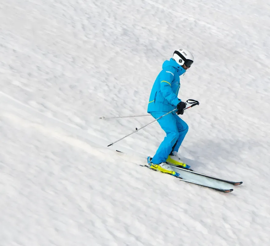 Uno sciatore che scende su una pista innevata in montagna vicino a Brașov