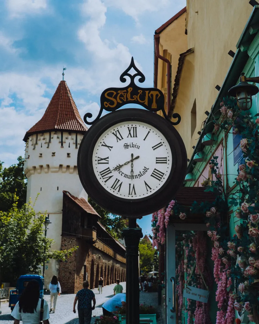 A street in the centre of Sibiu with an old clock and shop fronts