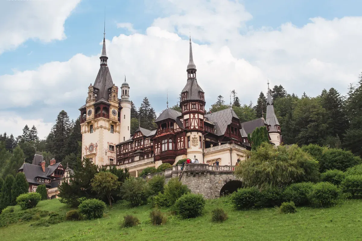 Peleș Castle among green trees and lawns in Sinaia
