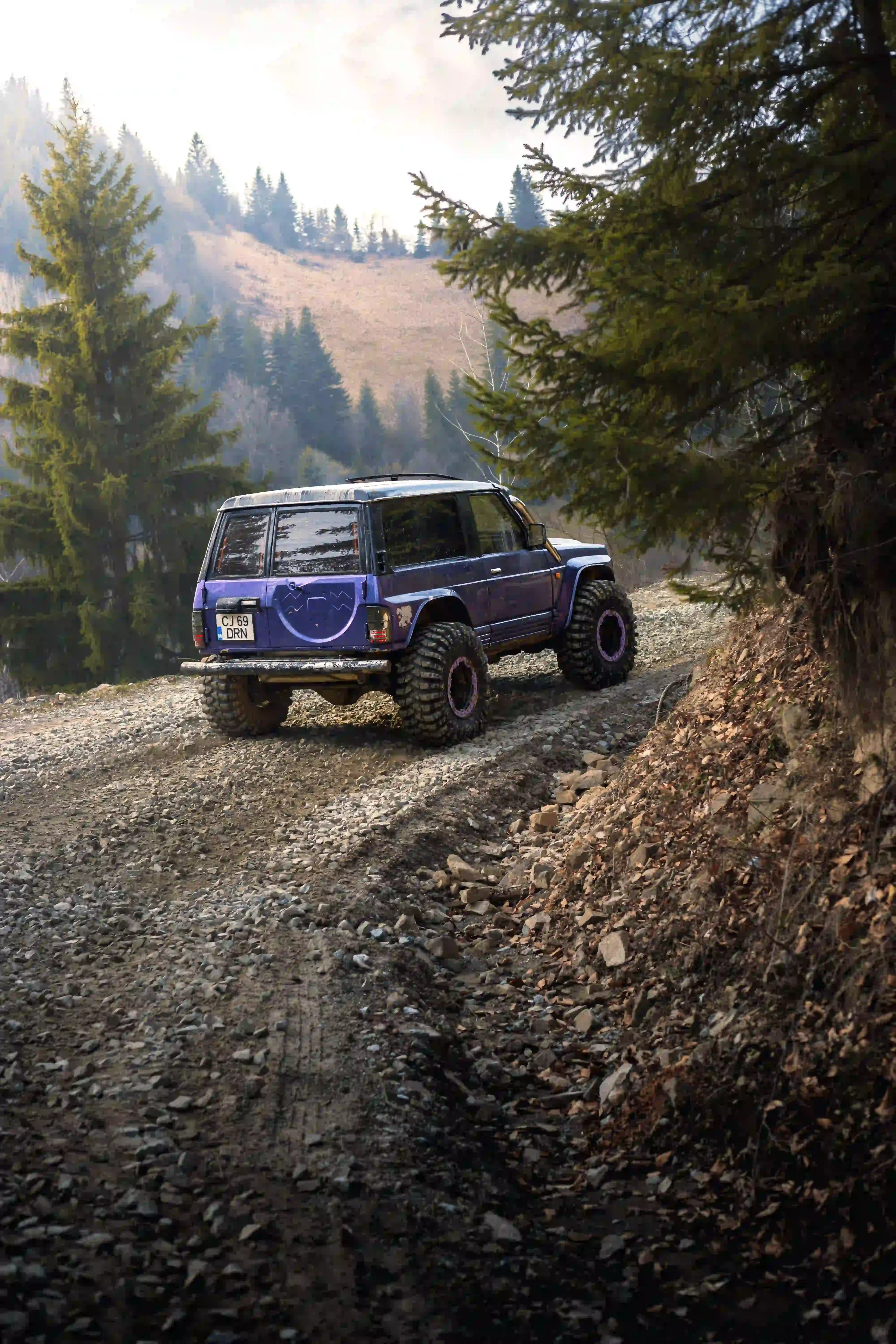 Off-road 4x4 vehicle on a rocky forest track in the mountains