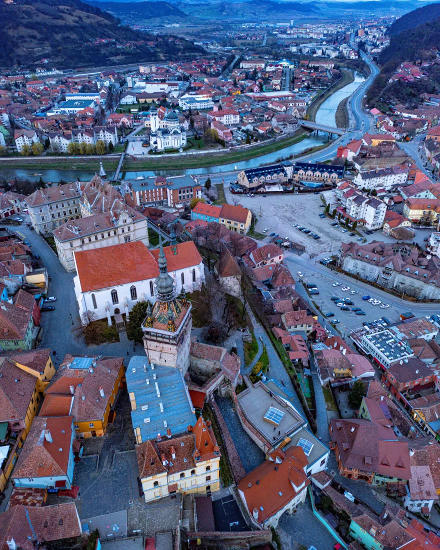 Aerial view of a historic town in Transylvania with its church and red rooftops