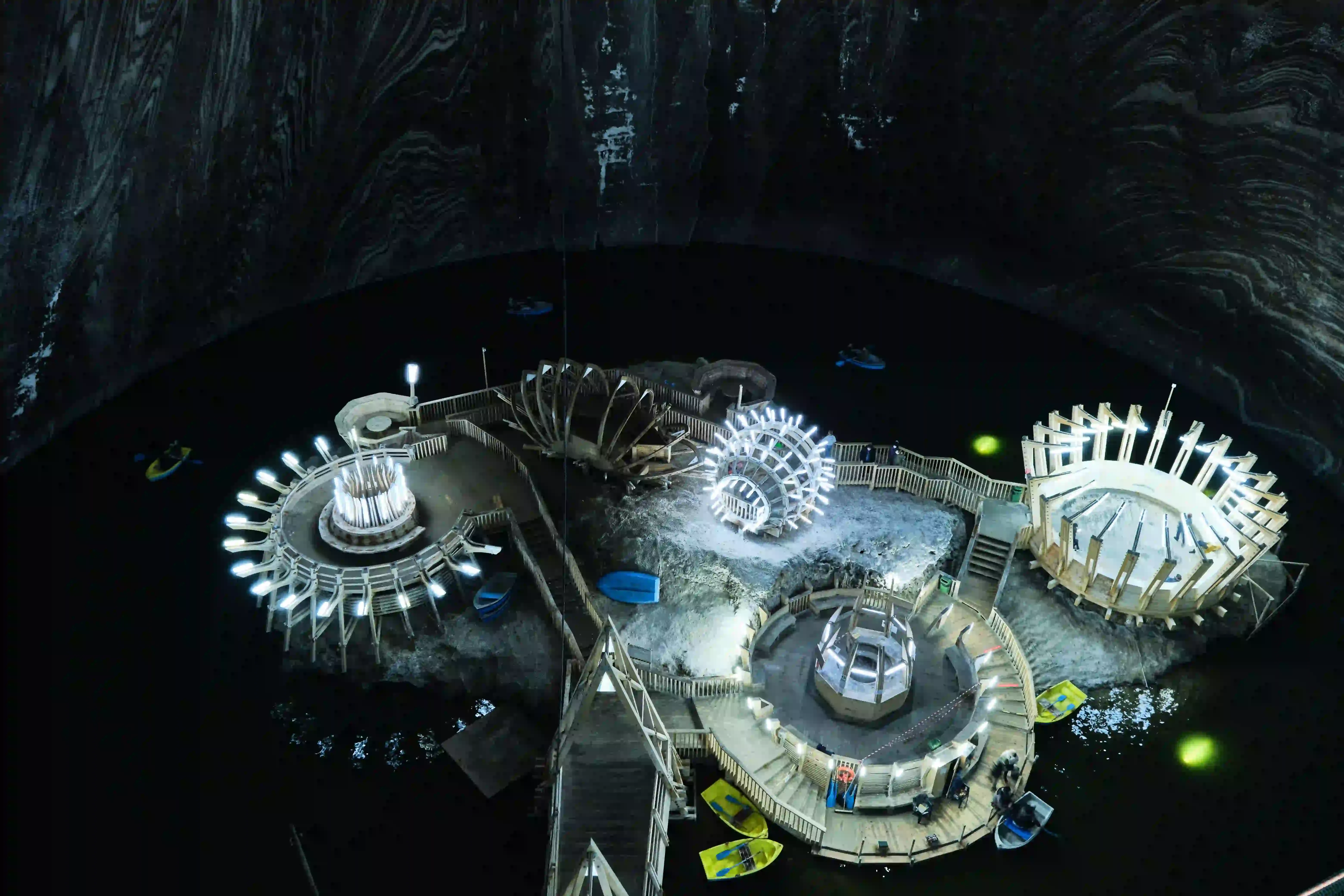 Illuminated attractions in the vast underground hall of the Salina Turda salt mine